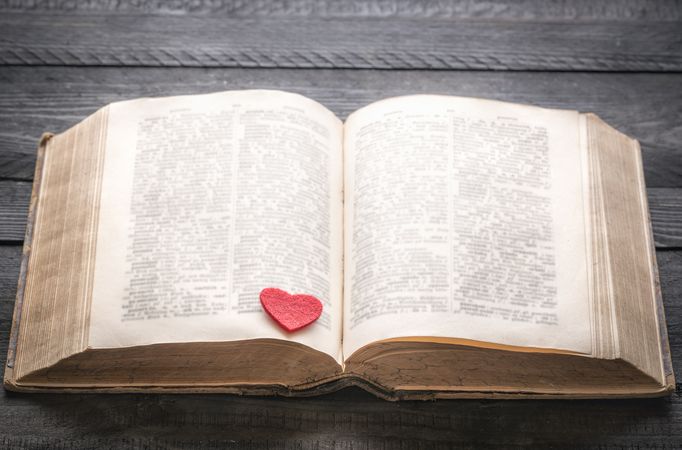 Red heart on an antique book