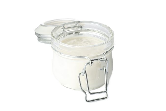 Glass jar with sour cream yogurt isolated on plain background