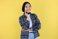 Young Asian Woman Wearing Scarf, Smiling to the Camera with hand on her Cheek