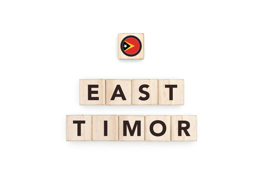 Wooden blocks bearing the name and flag of East Timor. Timorese and Austral Culture, national identity, travel, and geography in a copy space design.