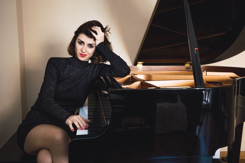 Young woman sitting at a piano posing