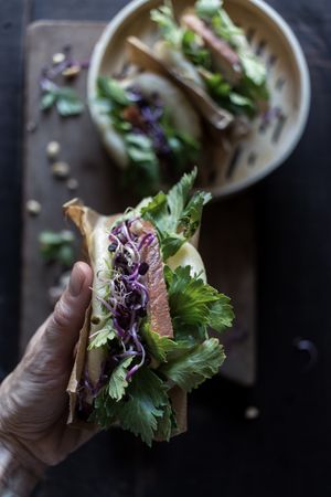 Crop person having traditional Gua Bao sandwich