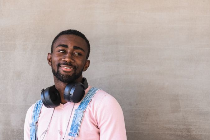 Smiling Black man with headphones on street