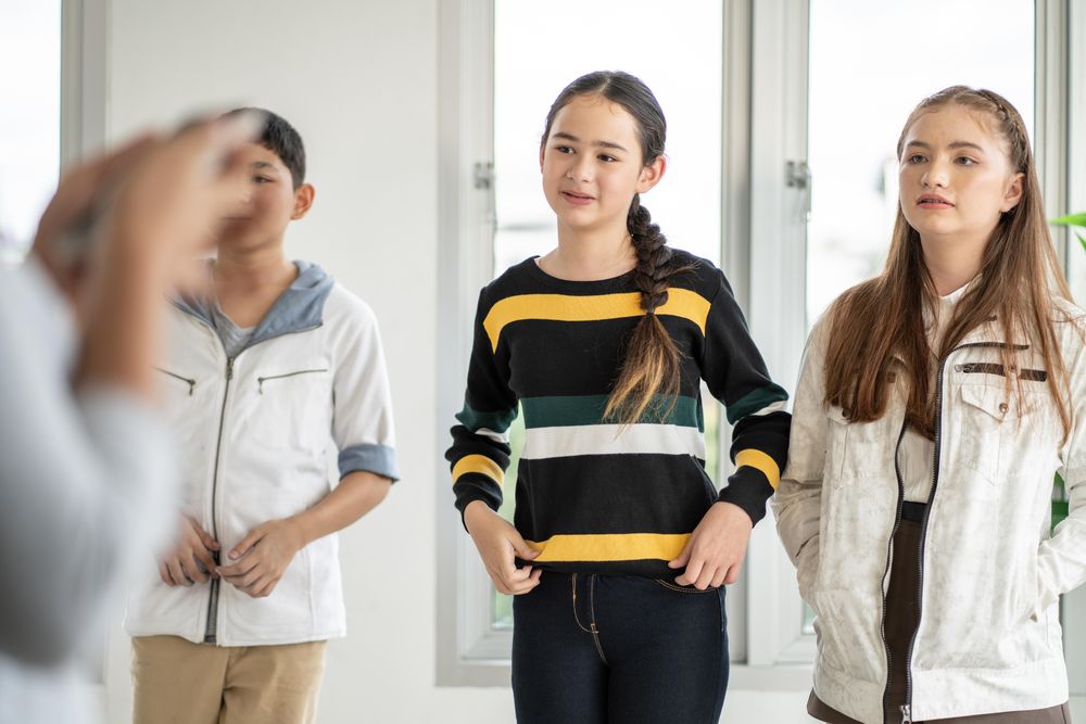 Female and male students standing in class