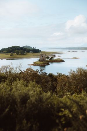 Ancient castle against hills on lake coast