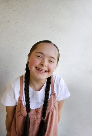 Happy child with braided hair looking at camera and smiling