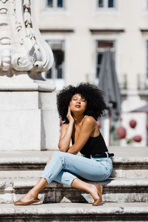 Black female siting on stairs outdoors