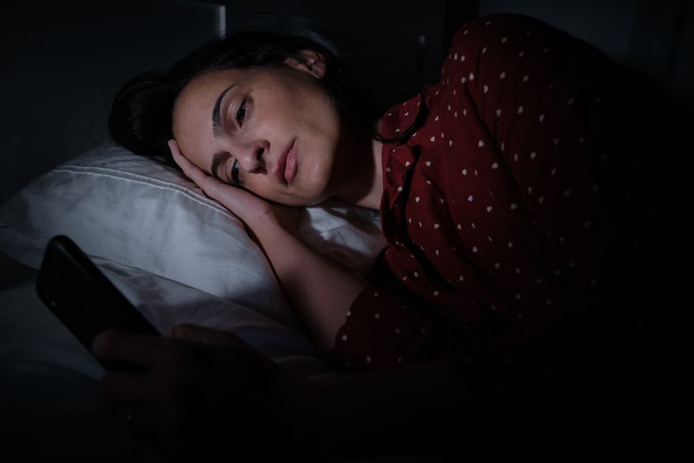woman browsing smartphone in darkness