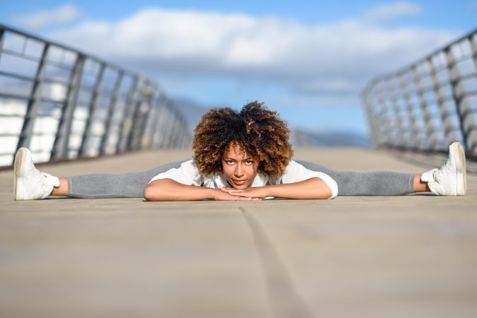 Woman leaning down on bridge while doing side splits