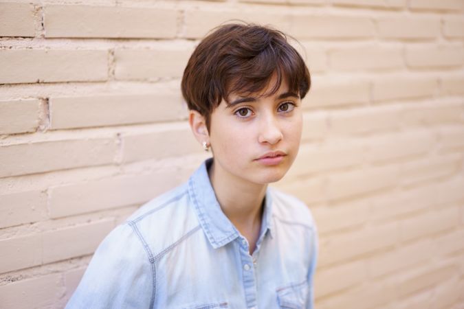 A Captivating Portrait of a Young Individual with Short Hair Wearing a Casual Denim Shirt