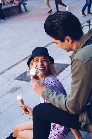 Happy couple feeding each other by ice cream