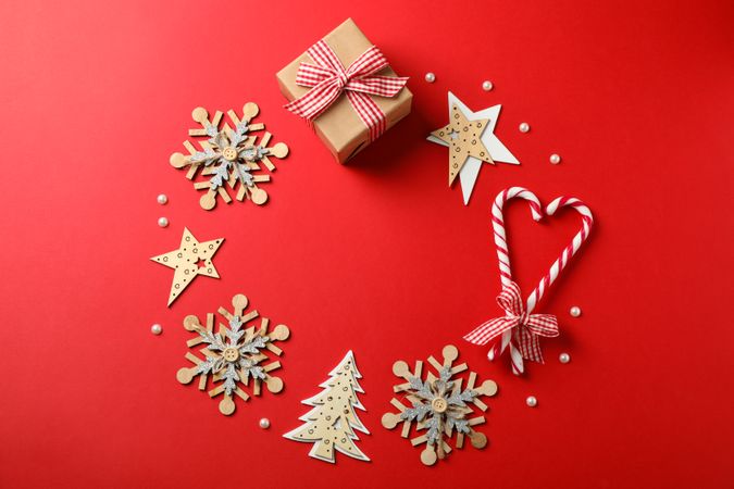 Candy canes and christmas accessories on red background, space for text