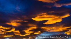 Orange clouds in blue sky background at sunset 4329qV