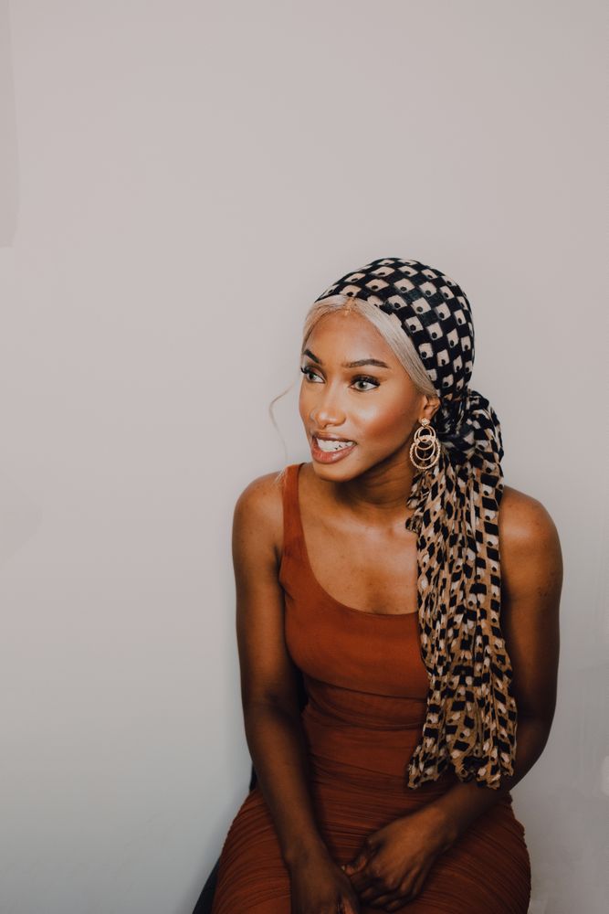 Black woman wearing headscarf and brown dress