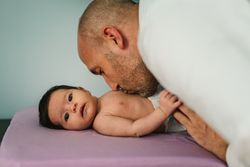Father kissing baby in belly