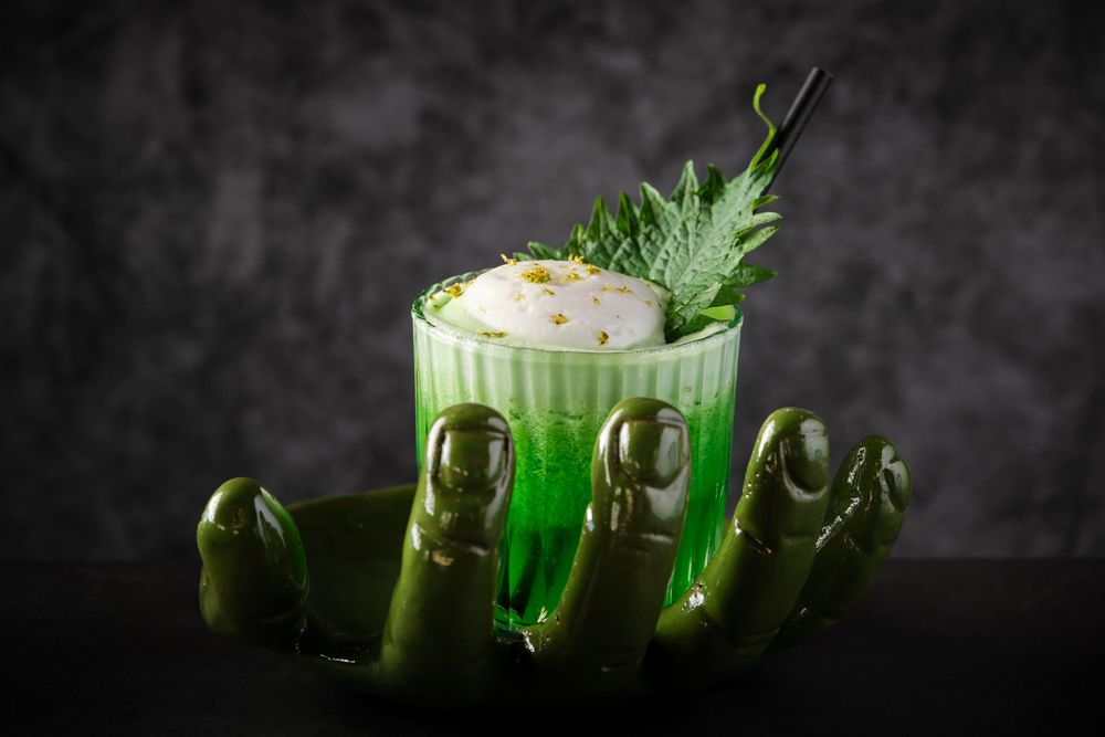 Green cocktail with shiso leaf served on creative plate