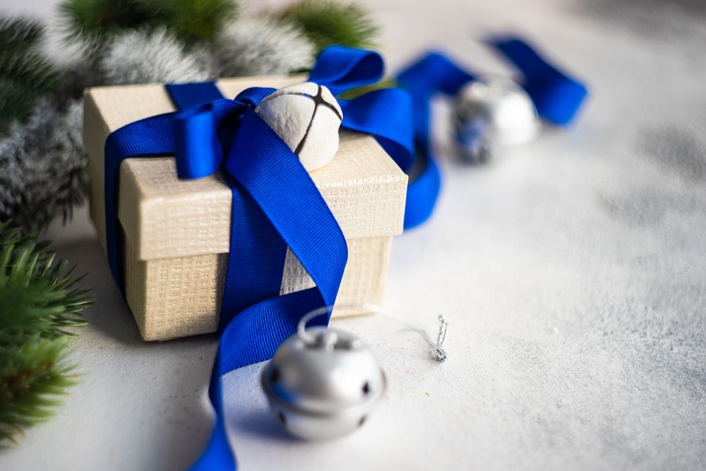 Christmas present with blue ribbon and silver bells