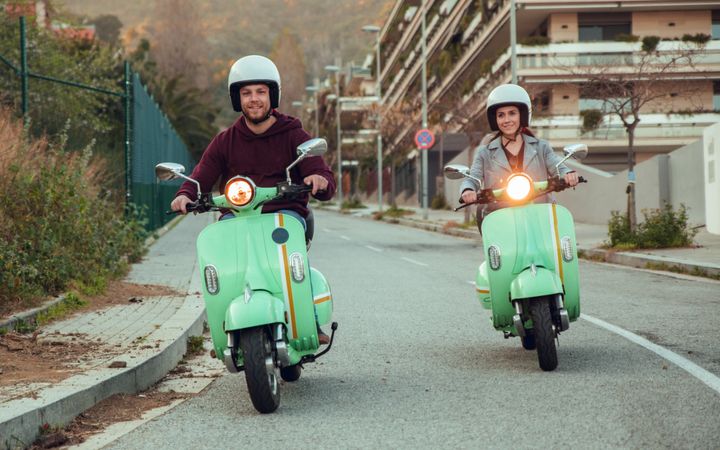 Young people riding motorcycles on city road