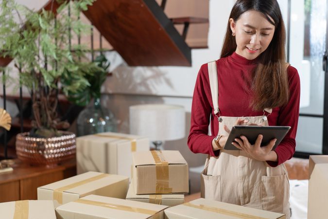 Female e-commerce business owner checking her tablet for shipments