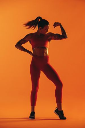 Portrait of female bodybuilder flexing biceps