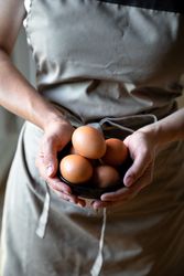 Faceless person holding bowl with eggs