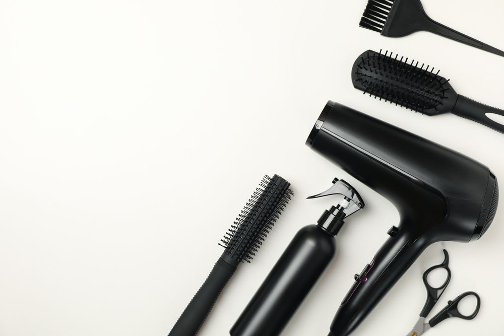 Composition with hairdresser accessories on blank background, space for text