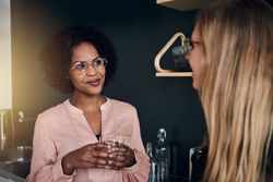 Two businesswomen having a chat in the office kitchen
