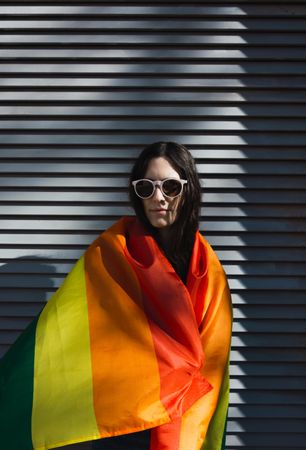 Woman posing happily with the LGBTQIA flag