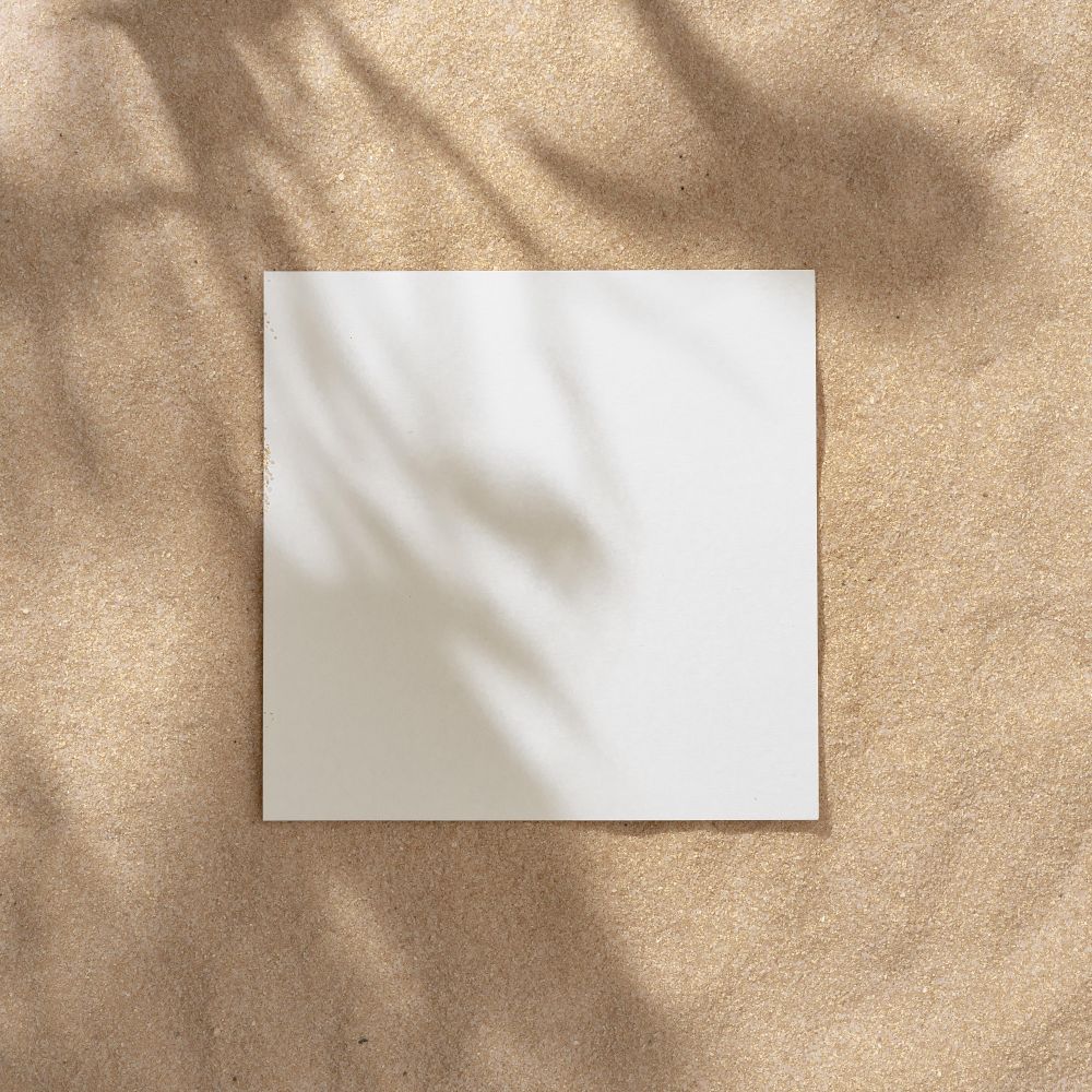 Sand with palm leaf shadows and central square