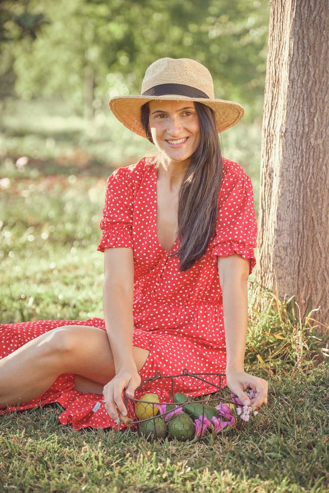 Young woman in summer dress sitting on grass