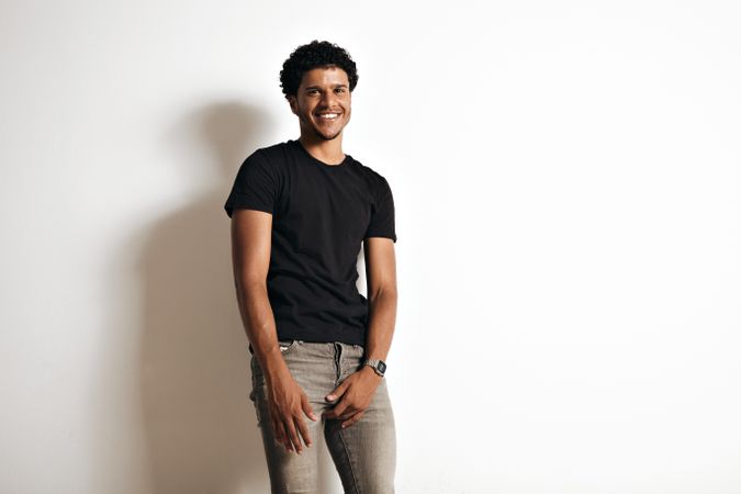 Smiling and content model in dark shirt and jeans