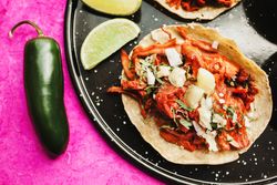 Pepper and lime near tacos al pastor and sauces