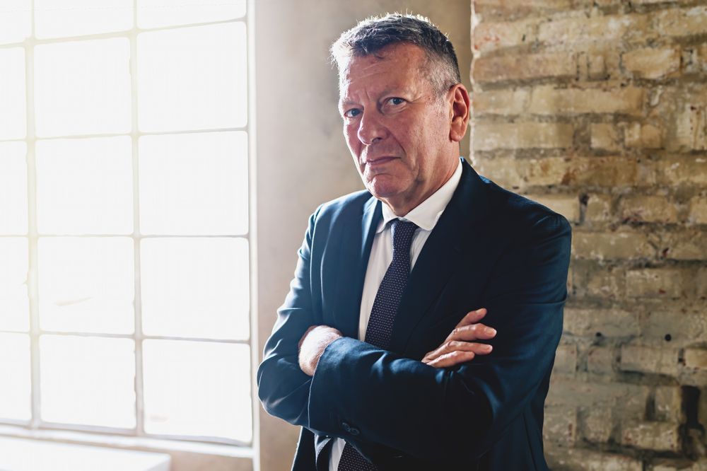 Portrait of a businessman with arms crossed near a window