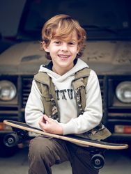 Smiling kid with skateboard on street