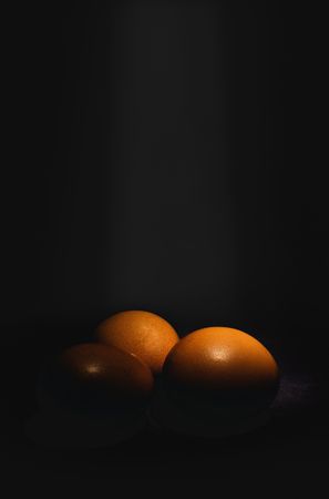 Raw eggs on dark background