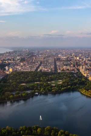New York Cityscape During Daytime. Aerial Photo from a Helicopter. Modern Skyscraper Buildings Around Central Park in Manhattan Island. Focus on Nature, Trees and Lakes in the Park in the City