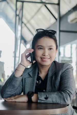 Cheerful businesswoman using smartphone during a break at cafe