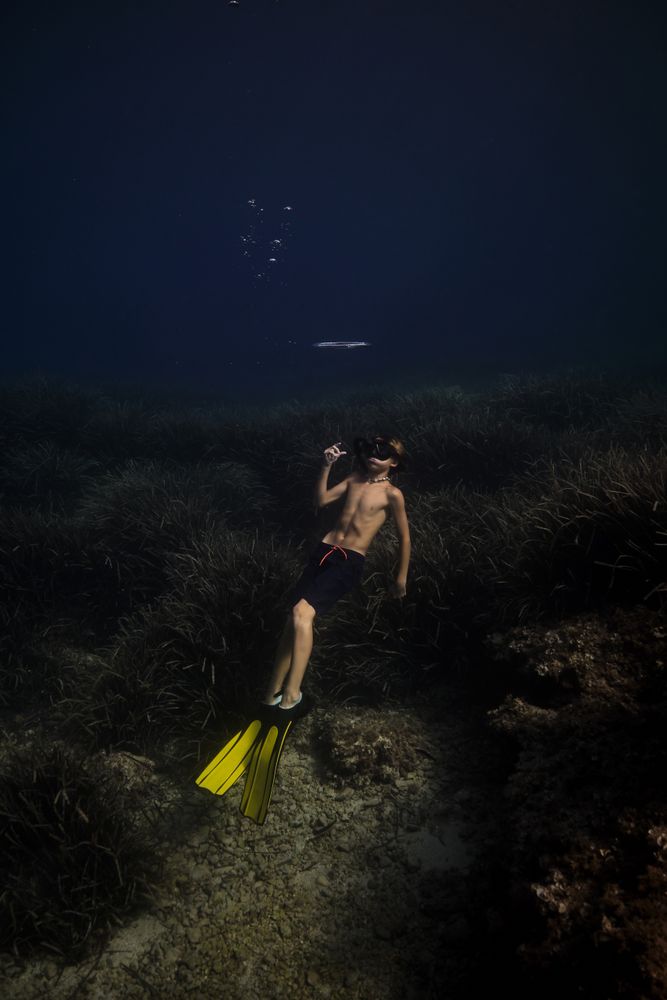 Anonymous boy diving in deep sea
