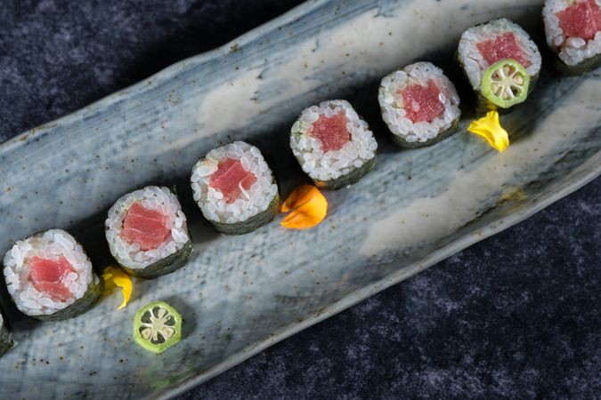 Appetizing sushi rolls with salmon on marble plate