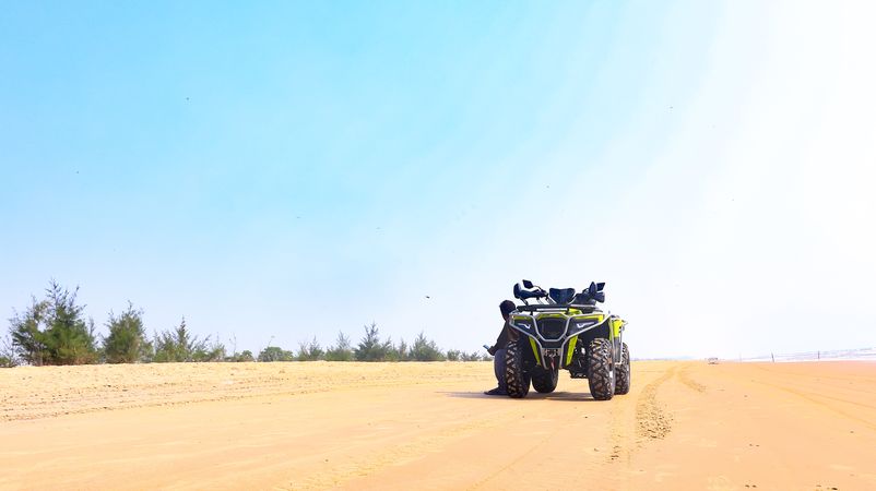 Two men riding ATVs on sandy terrain during a desert adventure
