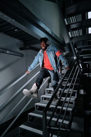 Young man jumping downstairs in building