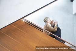 Older couple being affectionate on stairs beMpKb