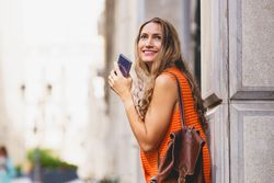 Woman looking around with phone
