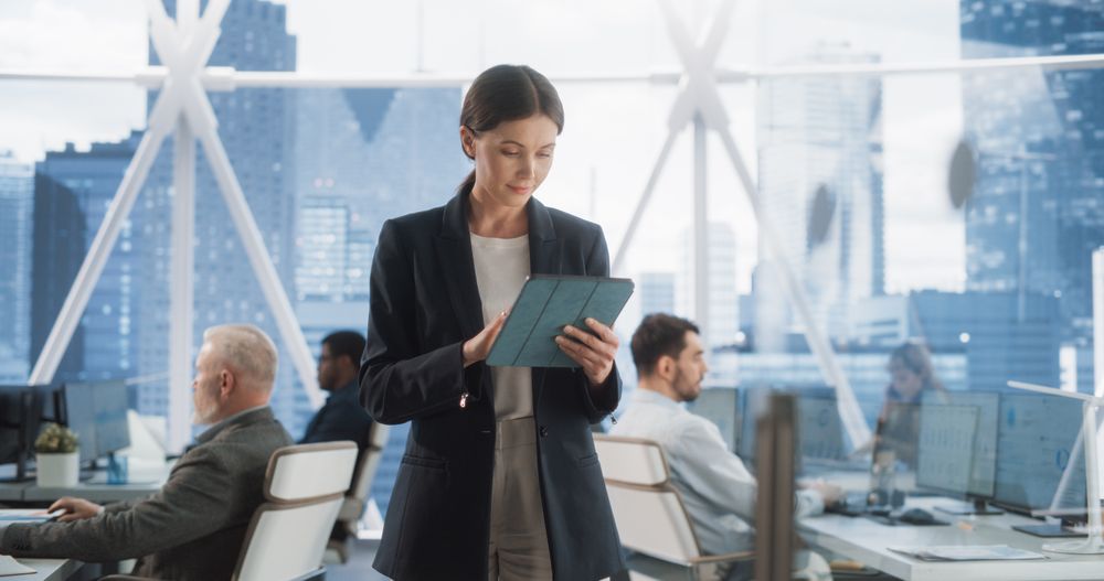 Successful Businesswoman Using Tablet Computer, Standing in Modern Diverse Office in Downtown