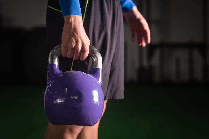 Man holding kettlebell on floor in gym