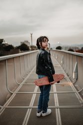 Girl with skateboard on walkway