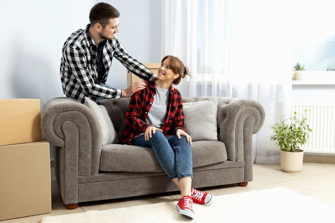 Moving concept, couple man and woman with boxes in apartment.