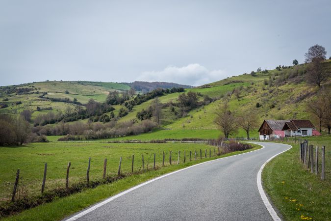 Asphalt road near houses and hills