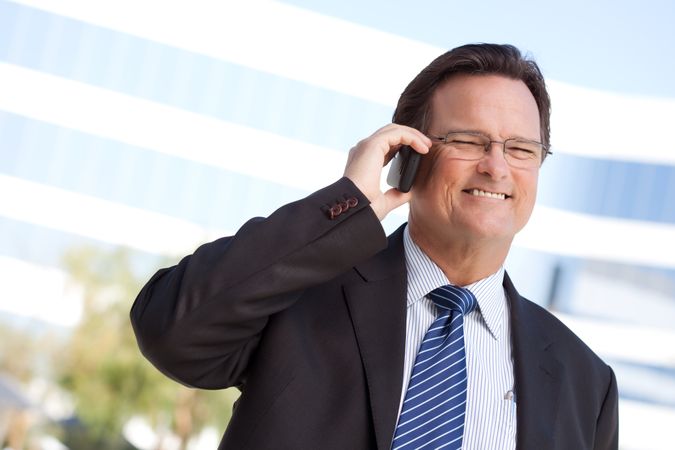 Businessman Smiles as He Talks on His Cell Phone