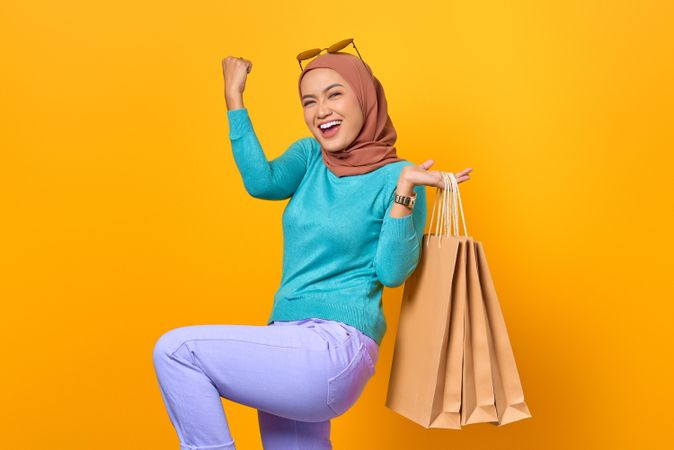 Muslim woman smiling with shopping bags on her back